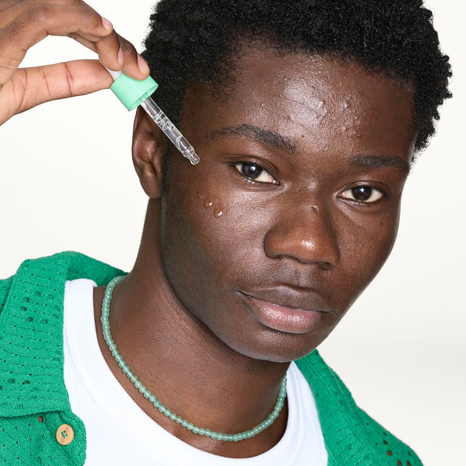 A close-up of man using serum